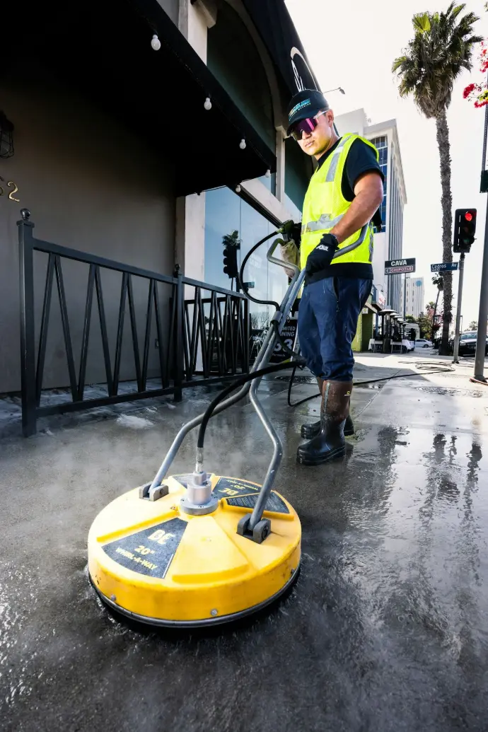 a man in a yellow vest is cleaning the street